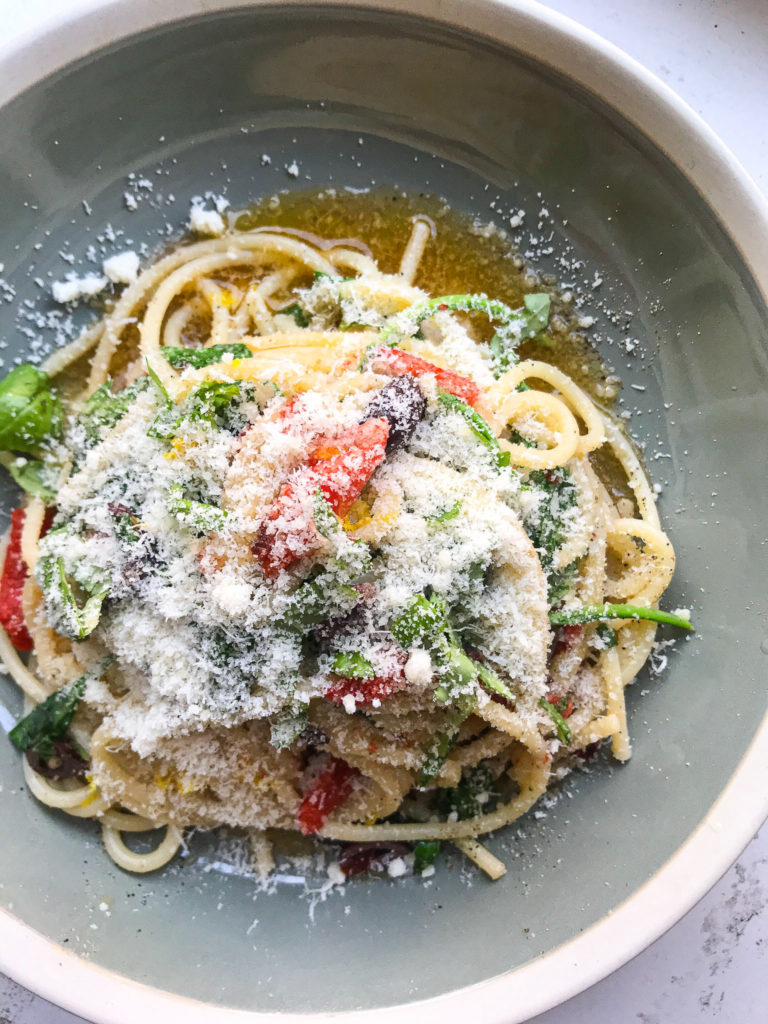 Bord met spaghetti aglio olio e peperoncino met Parmezaan